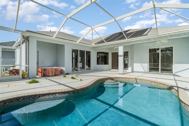 rear view of property with ceiling fan, a patio, glass enclosure, an outdoor pool, and a hot tub