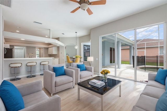 living room featuring ceiling fan and light hardwood / wood-style flooring