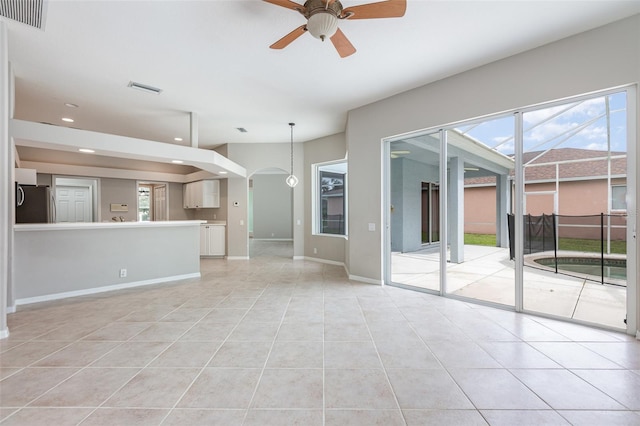 unfurnished living room featuring light tile patterned floors and ceiling fan