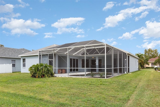 rear view of property with glass enclosure and a lawn