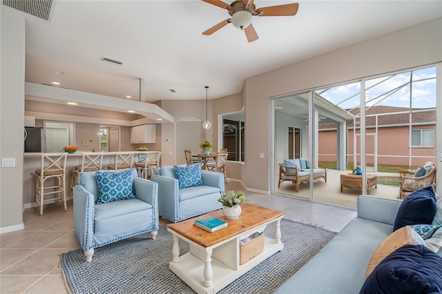 living area featuring a ceiling fan, visible vents, baseboards, and light tile patterned floors