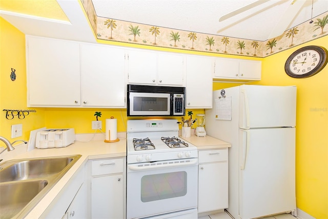 kitchen with white cabinets, white appliances, a textured ceiling, and sink