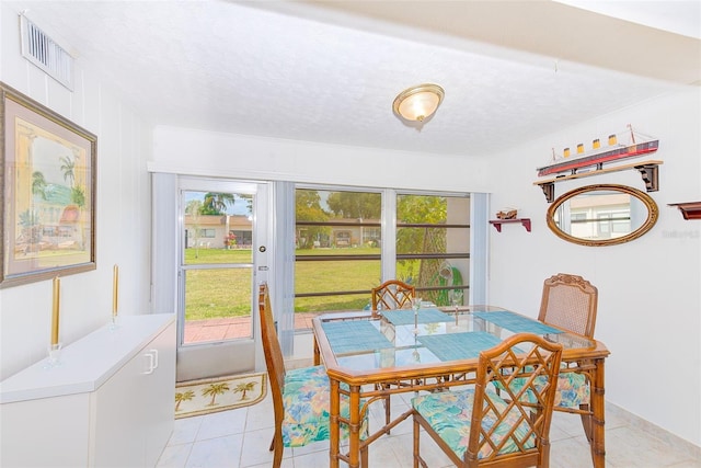 tiled dining space with a textured ceiling