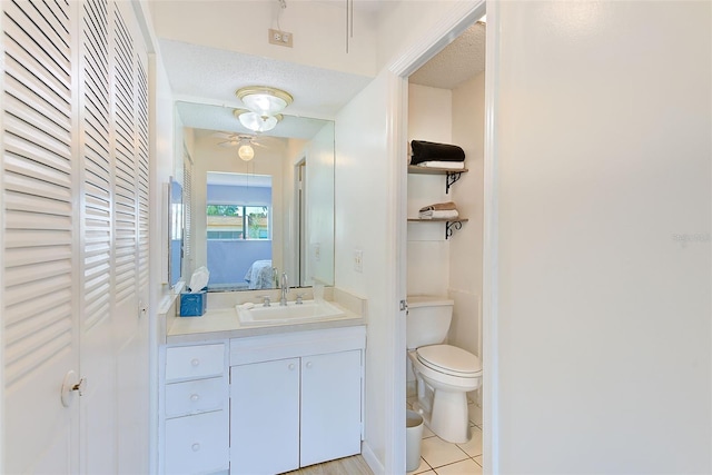 bathroom featuring vanity, tile patterned flooring, toilet, and a textured ceiling