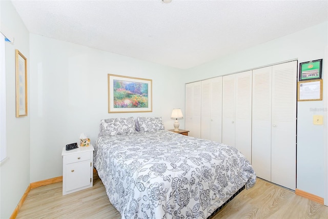 bedroom featuring a textured ceiling, a closet, and light hardwood / wood-style floors