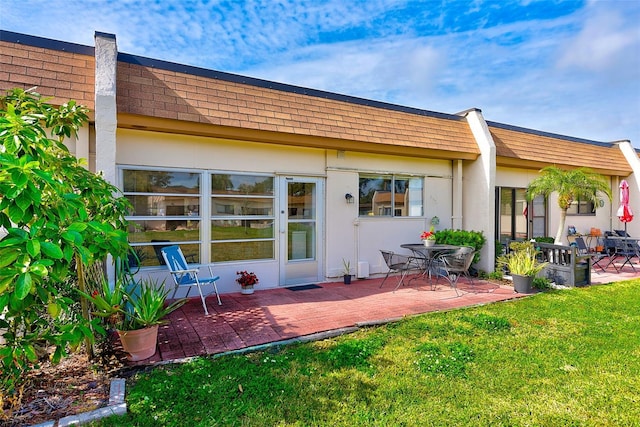 back of property with a lawn and a patio area