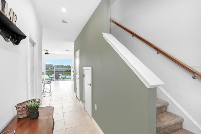 staircase featuring ceiling fan and tile patterned flooring