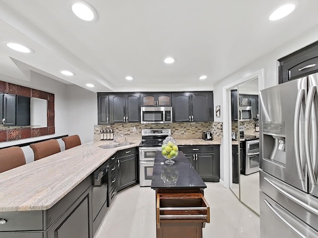 kitchen with tasteful backsplash, a center island, stainless steel appliances, and sink