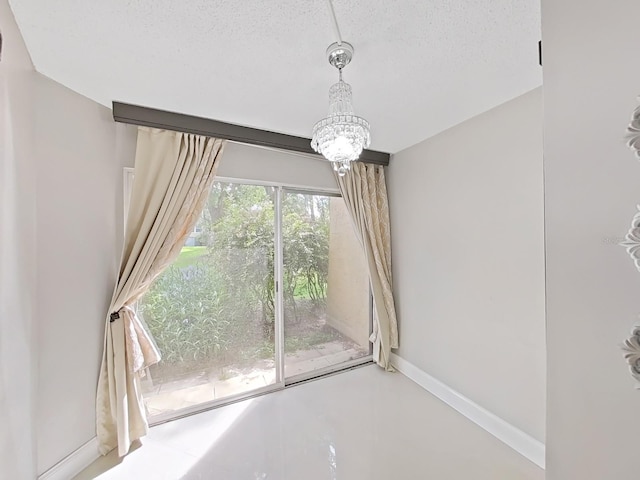 interior details featuring a textured ceiling, concrete floors, and an inviting chandelier