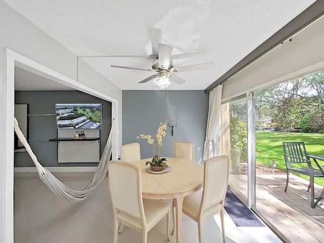 dining area with ceiling fan and a textured ceiling