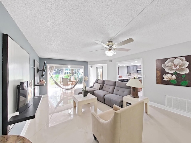 living room featuring ceiling fan and a textured ceiling