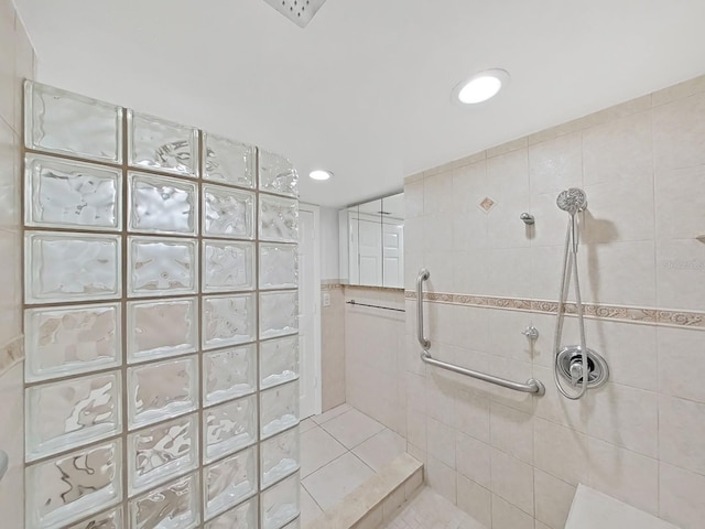 bathroom with tile patterned floors, tile walls, and tiled shower