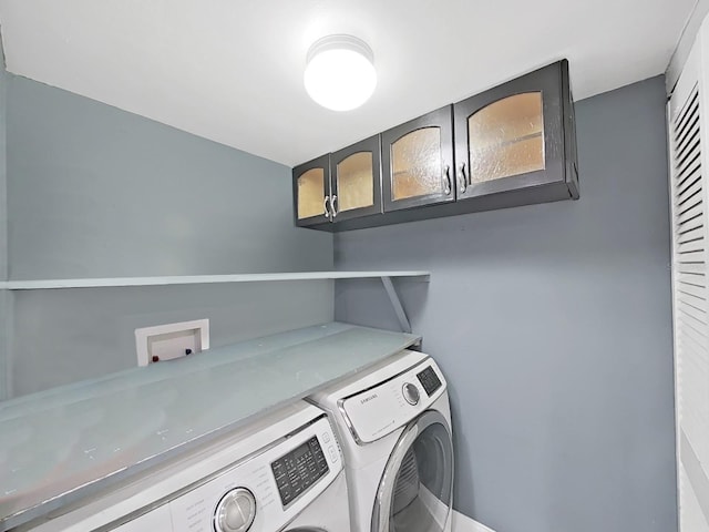 laundry area featuring washer and clothes dryer and cabinets