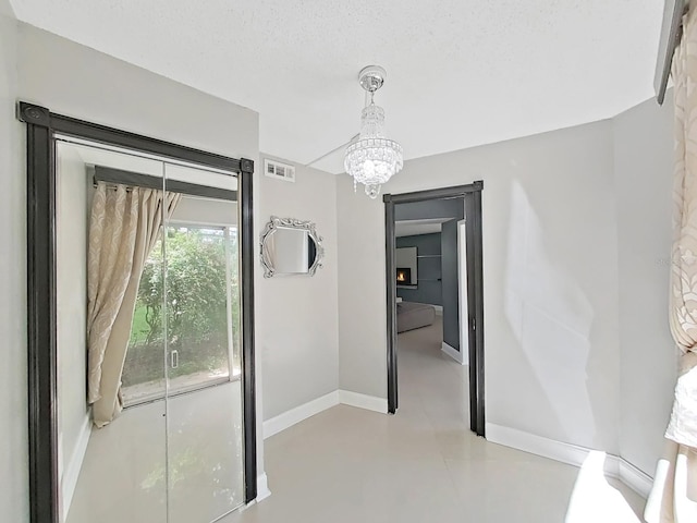 interior space featuring a textured ceiling and an inviting chandelier