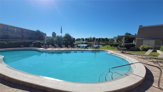 view of pool with a patio and a water view