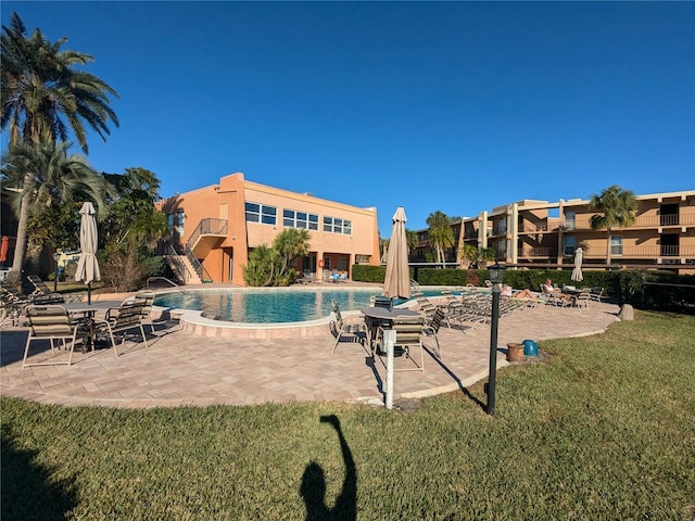 view of swimming pool with a patio and a lawn