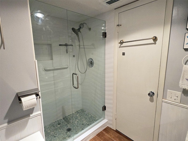 bathroom featuring hardwood / wood-style flooring and an enclosed shower