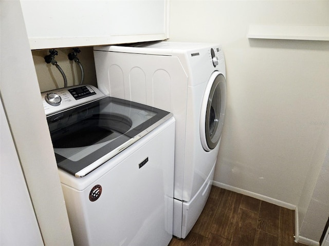 clothes washing area featuring washer and clothes dryer and dark hardwood / wood-style flooring