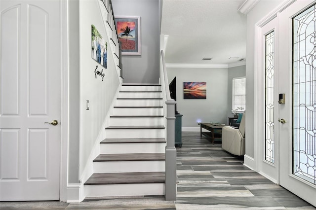 foyer entrance featuring crown molding and dark hardwood / wood-style floors