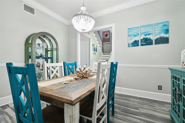 dining area featuring ornamental molding, dark hardwood / wood-style flooring, and a chandelier