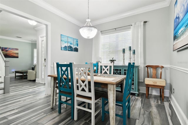 dining space featuring ornamental molding, an inviting chandelier, and hardwood / wood-style floors