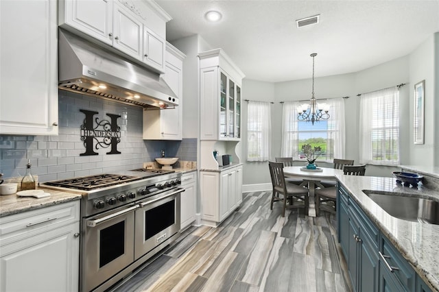 kitchen with double oven range, blue cabinets, and white cabinetry