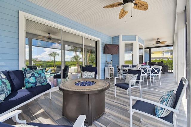 deck featuring ceiling fan and an outdoor fire pit