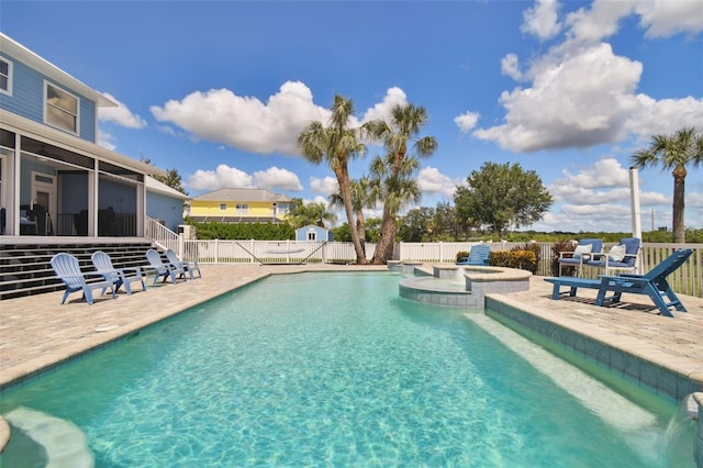 view of swimming pool featuring a sunroom, an in ground hot tub, and a patio