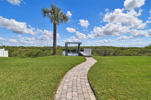 view of property's community with a water view and a yard