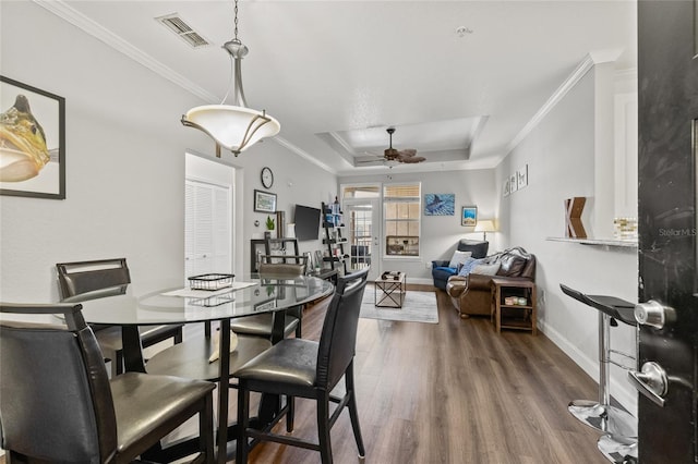 4221 W Spruce St Unit 1424, Tampa, FL 33607 - dining area with a tray ceiling, baseboards, wood finished floors, ceiling fan, and ornamental molding