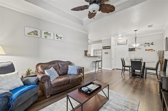 living room featuring ornamental molding, ceiling fan, and dark wood-type flooring