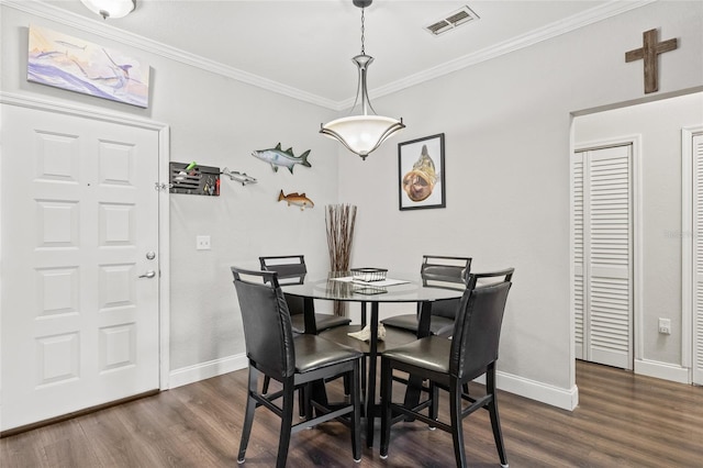 dining area with crown molding and dark hardwood / wood-style flooring