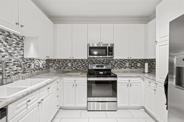 4221 W Spruce St Unit 1424, Tampa, FL 33607 - kitchen featuring stainless steel appliances, a sink, light tile patterned flooring, white cabinetry, and tasteful backsplash