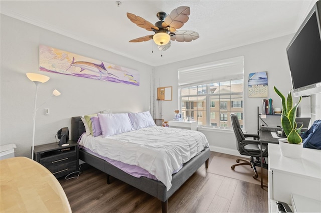 bedroom with ornamental molding, ceiling fan, and dark wood-type flooring