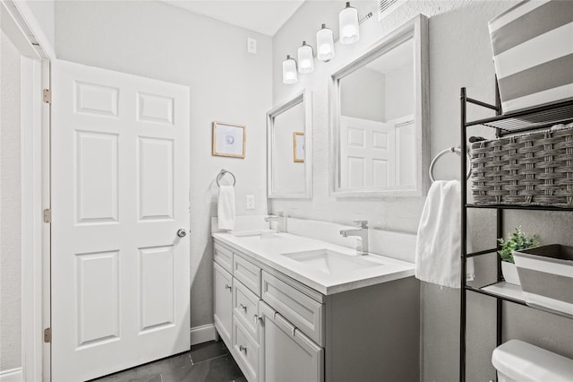 bathroom featuring vanity, tile patterned flooring, and toilet