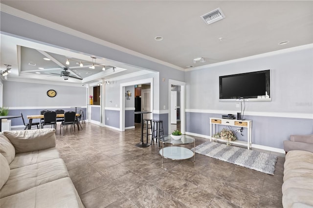 living room featuring crown molding, ceiling fan, and a raised ceiling