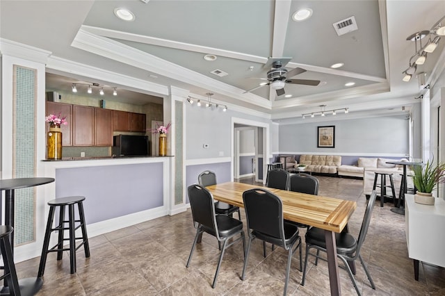 dining space featuring ceiling fan, a raised ceiling, and ornamental molding