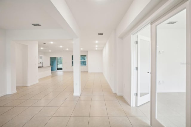 corridor with sink and light tile patterned floors