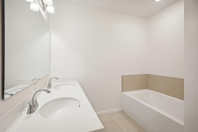 bathroom with a bathing tub, vanity, and tile patterned floors