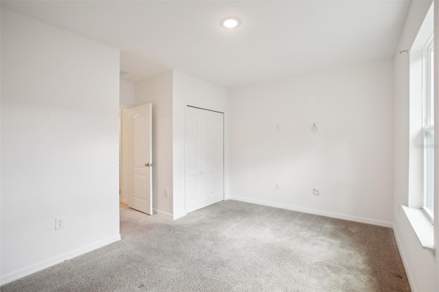 interior space featuring a closet, multiple windows, and light colored carpet