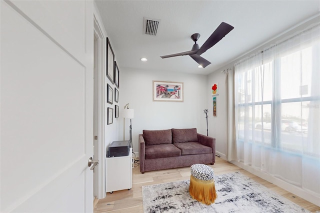 living room featuring ceiling fan and light hardwood / wood-style flooring