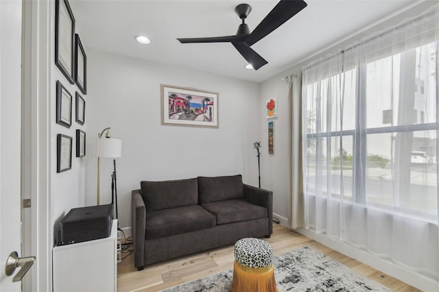 living room featuring light wood-type flooring and ceiling fan