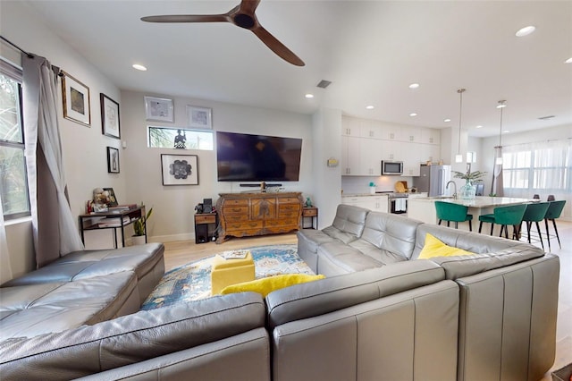 living room with ceiling fan, a healthy amount of sunlight, and light hardwood / wood-style floors