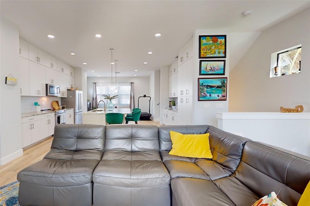 living room with light hardwood / wood-style flooring and sink