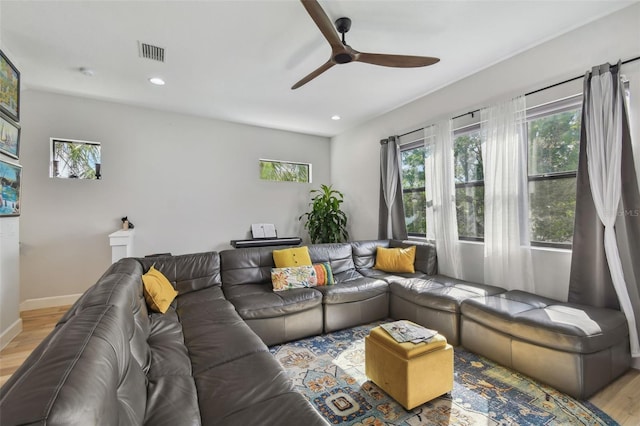 living room featuring ceiling fan and light hardwood / wood-style floors