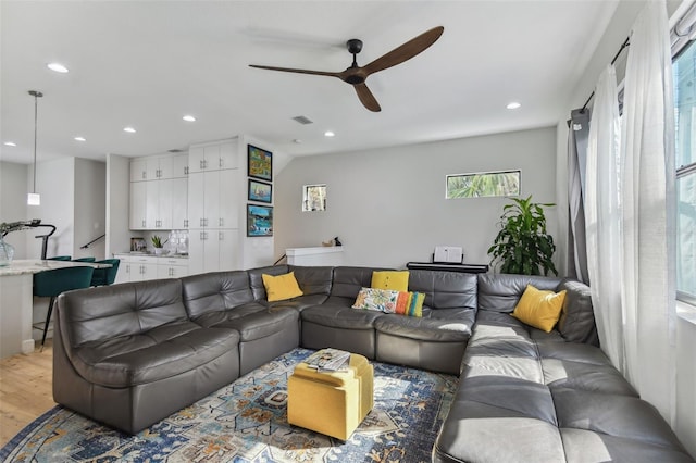 living room featuring ceiling fan and light hardwood / wood-style flooring