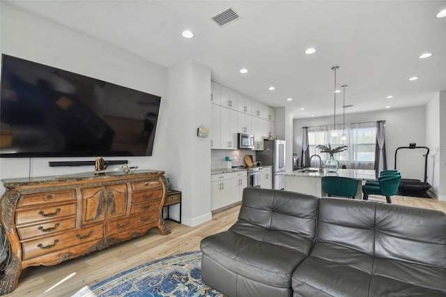 living room featuring sink and light wood-type flooring