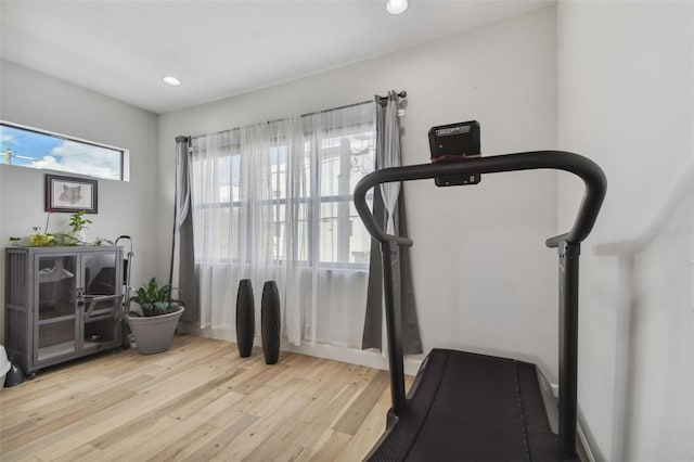 exercise room with light hardwood / wood-style floors