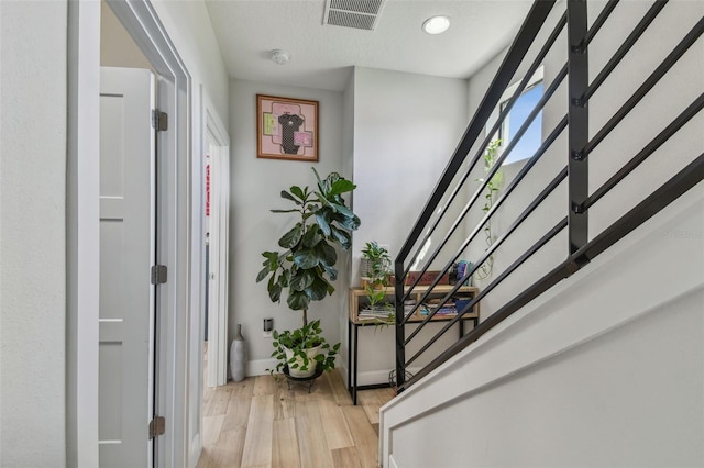 interior space featuring light wood-type flooring and a textured ceiling