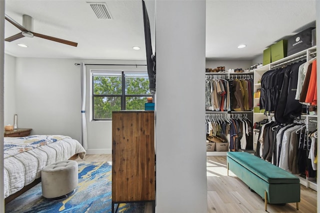 bedroom with ceiling fan, a closet, and light hardwood / wood-style floors